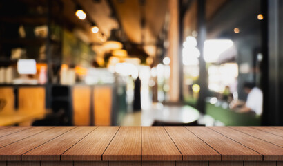 Empty wooden table top with lights bokeh on blur restaurant background.