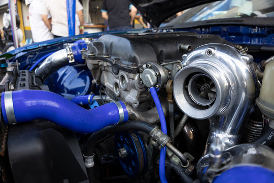 Engine assembly with a high performance turbocharger connected to the intake system through blue pressurized silicone hoses.