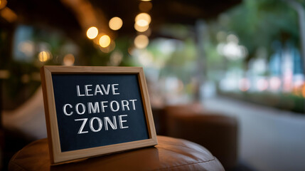 Chalkboard on table with outdoor view showing leave the comfort zone heavily defocused background motivational message visualization personal growth concept with copy space