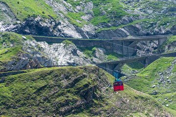 Highaltitude cable car traversing alpine canyon landscapes, Remote gondola ride crossing dramatic rocky and grassy mountain gorges under sunlight © Alexandr Macovethi