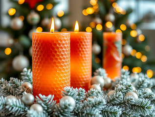 Title: Closeup of three lit orange candles on a bed of silver and white Christmas decorations