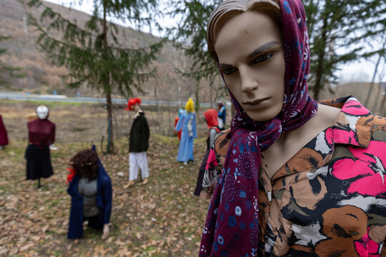 Vecchi paurosi manichini usati e rovinati con vestiti vintage e colorati lasciati nel bosco d&rsquo;inverno creano scene e ritratti inquietanti come nei film horror di zombie
