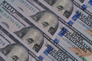 Hundred-dollar bills as background.