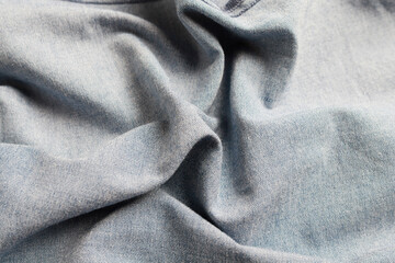 Dramatic lighting on denim fabric. Background, wallpaper.