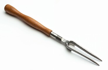 Fototapeta premium Fish processing tool with wooden handle, metal prongs. Used for holding fish securely. Sharp tines, sturdy construction ensure efficient handling. Essential kitchen utensil for seafood preparation.