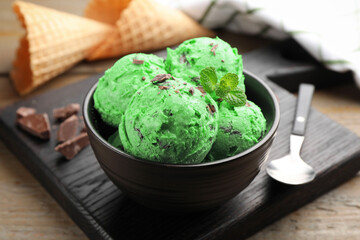 Yummy mint chocolate chip ice cream served on wooden table, closeup