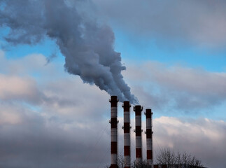 Four industrial chimneys producing smoke pollution