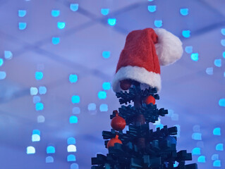 Santa Clause cap on New Year's fir tree bokeh