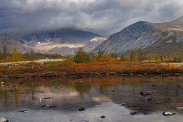 Autumn Mountain Valley Landscape With Dark Clouds Over Vibrant Tundra and Lake