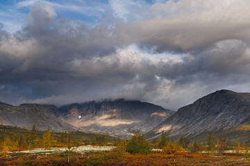 Autumn Mountain Valley Landscape With Dark Clouds Over Vibrant Tundra and Lake
