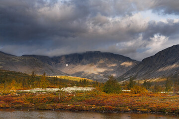 Autumn Mountain Valley Landscape With Dark Clouds Over Vibrant Tundra and Lake