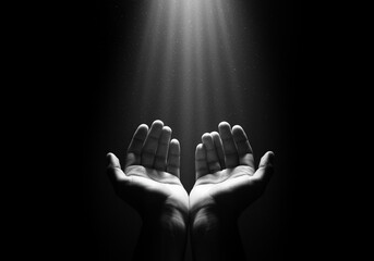 Hands reaching up towards light beams in darkness open