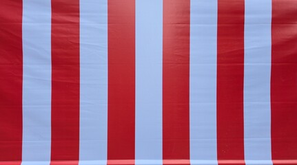 Close-up of vibrant red and white vertical striped canvas texture, ideal for abstract backgrounds in designs related to summer, beach, circus, or Christmas themes.