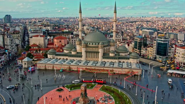Daytime aerial view of Taksim Square and Taksim Mosque in Istanbul. A dynamic city center scene featuring pedestrian and vehicle traffic, modern urban life, and architectural harmony.
