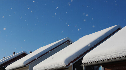 Snowy rooftops on a clear winter day with snowfall