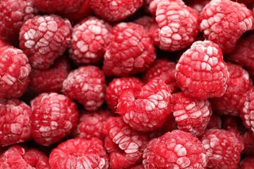 Frozen ripe raspberries as background, top view