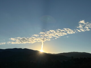 Contrail and clouds at dawn over Santa Fe, NM