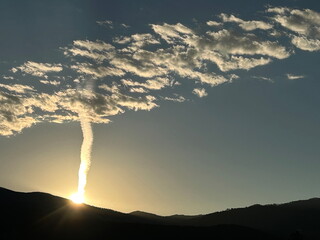 Contrail and clouds at dawn over Santa Fe, NM