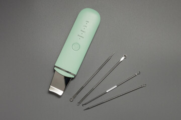 Mechanical skin cleansing. Ultrasonic facial cleansing tools. Skin care kit for a cosmetologist on a gray background.