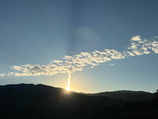 Contrail and clouds at dawn over Santa Fe, NM