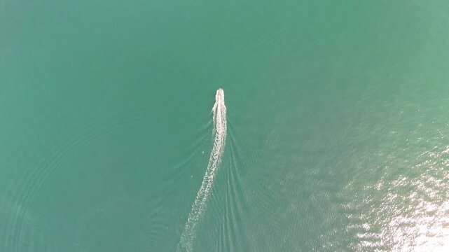 Top view aerial shot of light reflecting on the sea surface, creating a calm and abstract marine background with natural sunlight and gentle water texture