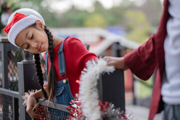 The children are celebrating Christmas and decorating the Christmas tree together.