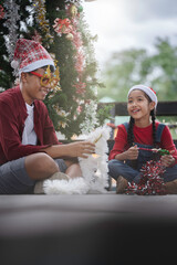 The children are celebrating Christmas and decorating the Christmas tree together.