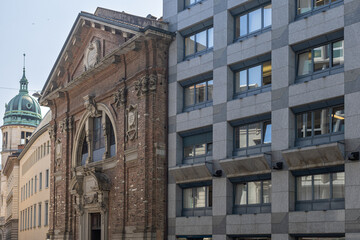 Fototapeta premium Historic Brick Facade With Ornate Archway And Green Dome Tower In City Street, Sant'Antonio Abate, Lugano, Switzerland
