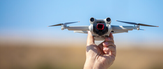 Quadcopter in flight against the sky. A small drone takes off from a person's hand.