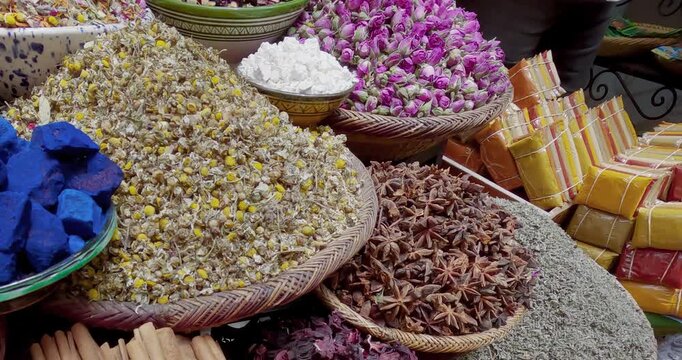 Close-up view of neatly arranged spices and herbs in woven baskets at an outdoor market