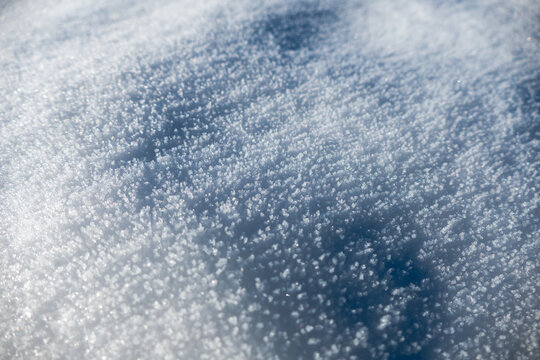 Nahaufnahme von Schneekristallen auf verschneiter Oberfl&auml;che