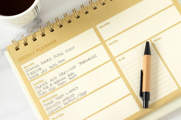 Christian weekly planner notebook with coffee cup. Top view. Daily goals, to do list, personal aspirations concept.