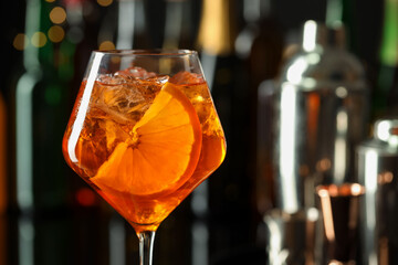 Glass of refreshing spritzer cocktail in bar, closeup. Space for text