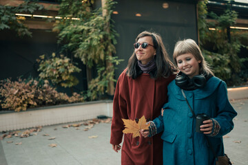 Mother and daughter wearing coats have a walk in city at autumn evening