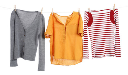 Different clothes drying while hanging on clothesline against white background