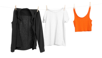 Different clothes drying while hanging on clothesline against white background