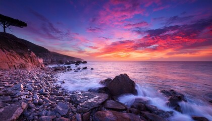 A Serene Coastal Scene At Dawn Showcases Vibrant Hues In The Sky Above A Calm Ocean Gently Caressing The Rocky Shore