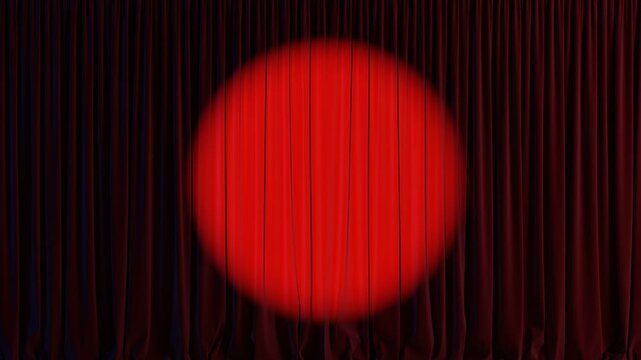 Bright red circle shines on dark curtain in theater. Empty theater stage with red velvet curtains and spotlight.