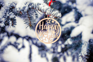 Happy New year on the snow-covered branches of a fir tree
