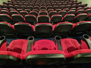 Fototapeta premium Rome, Italy - December 24, 2025, view of the empty stalls of a cinema, with particular attention to the rows of seats facing the big screen.
