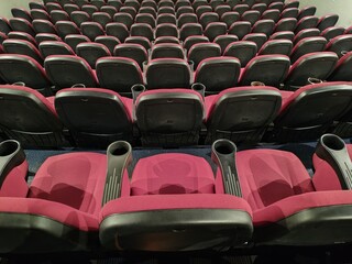 Fototapeta premium Rome, Italy - December 24, 2025, view of the empty stalls of a cinema, with particular attention to the rows of seats facing the big screen.