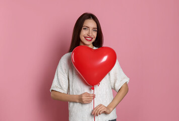 St. Valentine's Day. Woman with heart shaped balloon on pink background