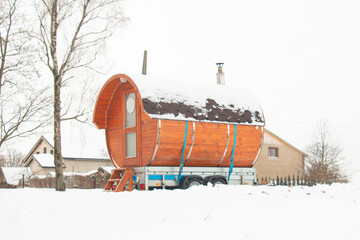 Mobile bathhouse in the form of a wooden barrel on a frosty winter day. Health improvement