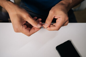 Close-up of technician hands replacing sim card in smartphone, providing efficient customer support and resolving connectivity issues. Concept of modern communication and technology.