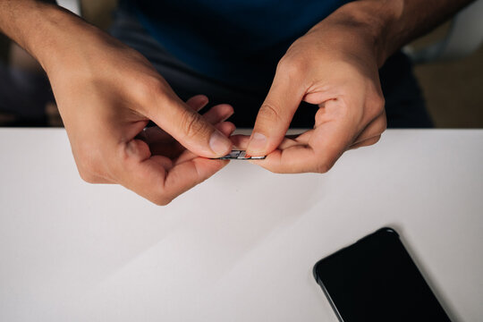 Close-up of technician hands replacing sim card in smartphone, providing efficient customer support and resolving connectivity issues. Concept of modern communication and technology. - Powered by Adobe
