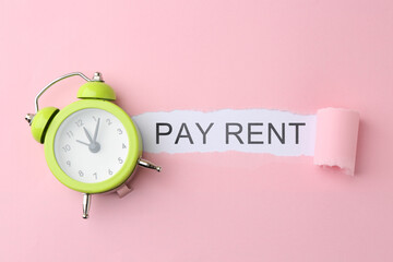 Pay rent. Alarm clock and torn paper, top view