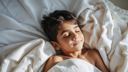 Peaceful young boy sleeping soundly in soft white bedding bathed in warm sunlight