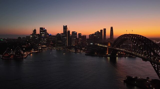 Sunset dark Circular Quay waterfront across Harbour in Sydney &ndash; aerial cityscape view.