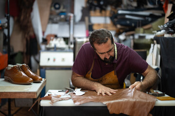 Cobbler at work shaping leather in a busy workshop, crafting handmade shoes with care.