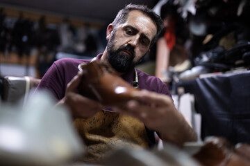 Cobbler at work shaping a leather shoe in a busy workshop, focused and skilled